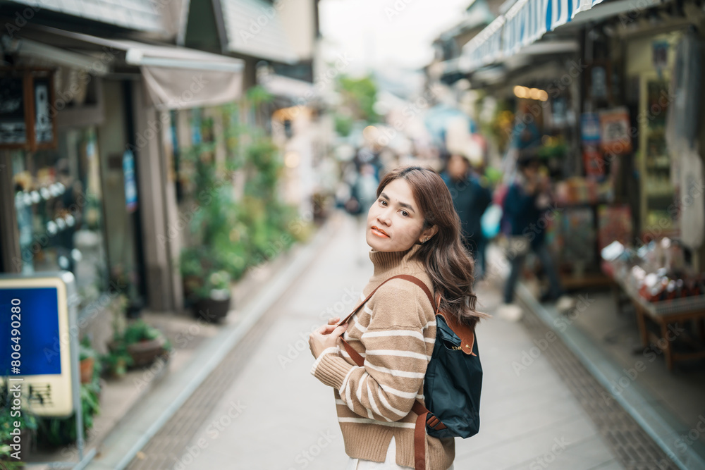 Woman tourist Visiting in Enoshima Island, Fujisawa, Kanagawa, Japan. happy Traveler sightseeing Enoshima Shrine. Landmark and popular for tourists attraction near Tokyo. Travel and Vacation concept