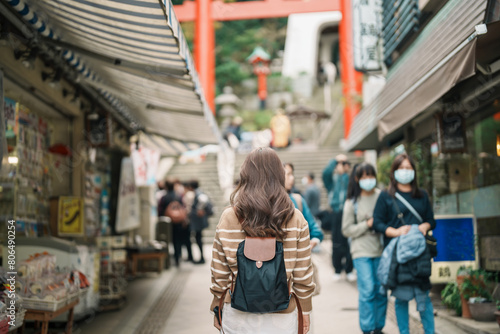 Woman tourist Visiting in Enoshima Island, Fujisawa, Kanagawa, Japan. happy Traveler sightseeing Enoshima Shrine. Landmark and popular for tourists attraction near Tokyo. Travel and Vacation concept photo