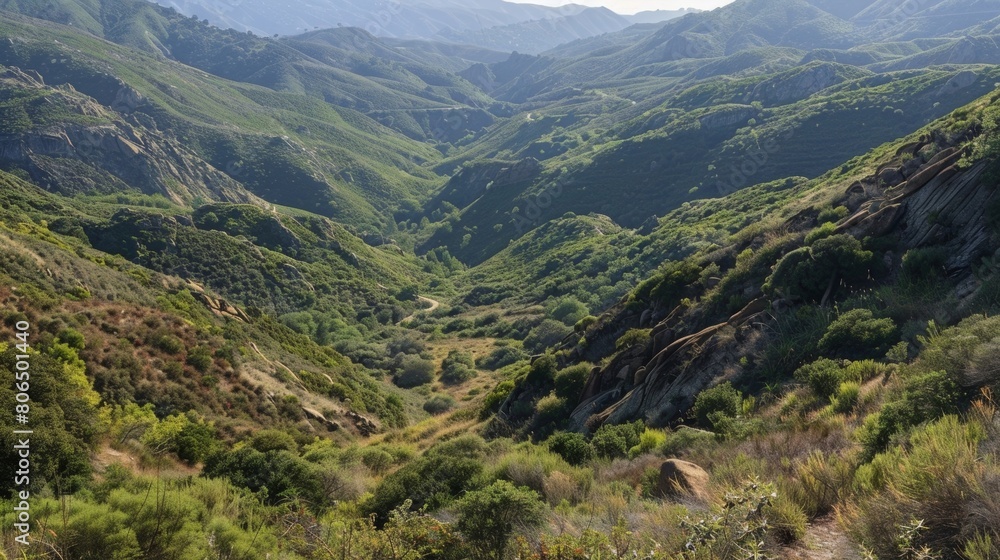 A panoramic view of the surrounding mountains and valleys with the trail winding its way through them.