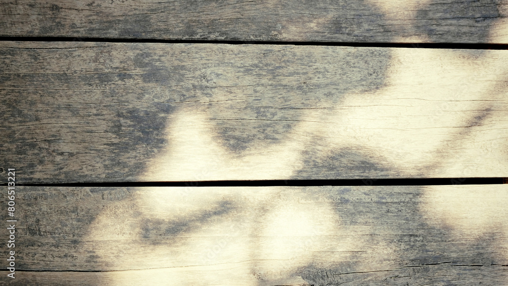 Fototapeta premium Solid wood plank background with reflection of leaves and sunlight with a yellow-gray gradient. For backdrops, banners, summer, old, dry scenes.