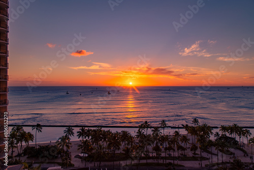 The sun setting over the Pacific Ocean at Waikiki Beach, Honolulu, Oahu, Hawaii