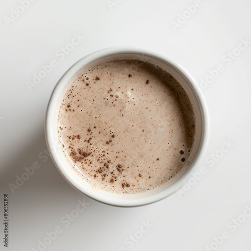 Dark beige grain shake in a white porcelain cup, top view, white background