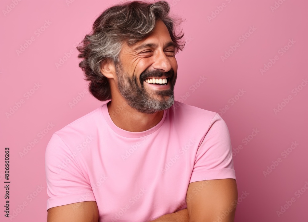 A man with a beard and gray hair is smiling and wearing a pink shirt A man with a beard and gray hair is smiling and wearing a pink shirt