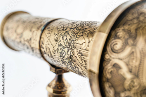 An antique brass telescope with an extendable tube and intricate engravings