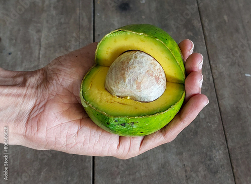 Hand holding green ripe crosscut avocado