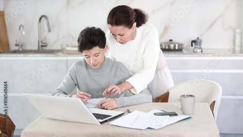 Mom helps her teenage son do schoolwork, solve problems together and find answers photo