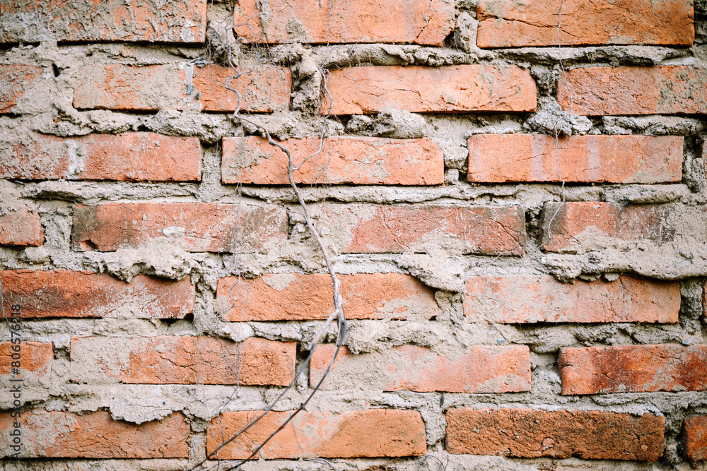 Fototapeta premium Neatly arranged layers of red brick make up the outer surface of a wall, exuding a rustic charm and timeless elegance.