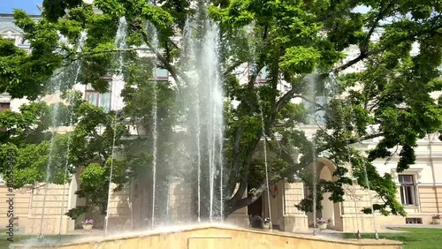 Fountain in front of City Hall of Iasi Romania on a sunny day filmed in slow motion photo