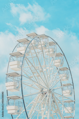 Ferris wheel for panoramic view in amusement park is popular entertaining ride, shot against summer sky on bright sunny day