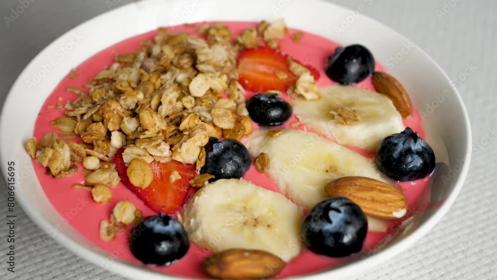 Pour cereal granola into fresh berry yogurt in a bowl with banana slices, strawberries and blueberries for a healthy breakfast. Oatmeal muesli in natural yoghurt. Vegetarian food concept. Pour cereal granola into fresh berry yogurt in a bowl with banana slices, strawberries and blueberries for a healthy breakfast. Oatmeal muesli in natural yoghurt. Vegetarian food concept.