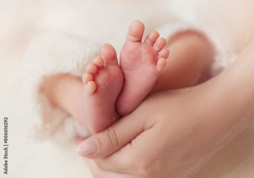 Baby Feet in Mother Hands. Newborn Toes Close up over White Soft background. Mum holding Tiny Feet with Love. Maternity and Childcare Concept Baby Feet in Mother Hands. Newborn Toes Close up over White Soft background. Mum holding Tiny Feet with Love. Maternity and Childcare Concept