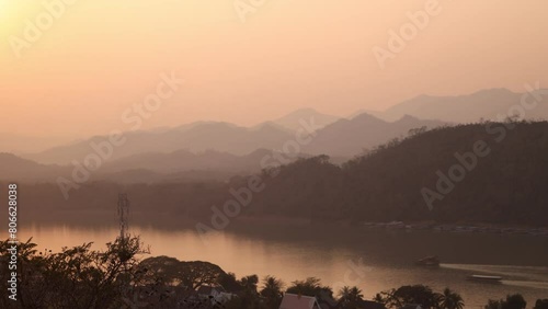 golden glow of sunset over the mekong river in Luang Prabang, Laos traveling Southeast Asia photo