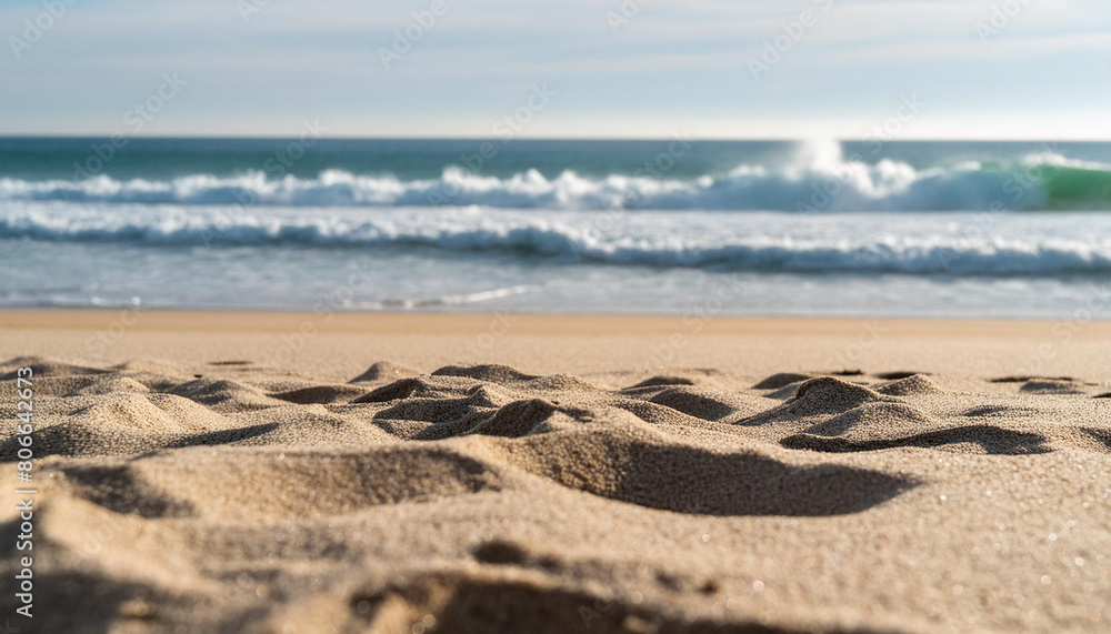 Close-up of sandy beach textures with out-of-focus waves in the background, concept of tranquility Close-up of sandy beach textures with out-of-focus waves in the background, concept of tranquility