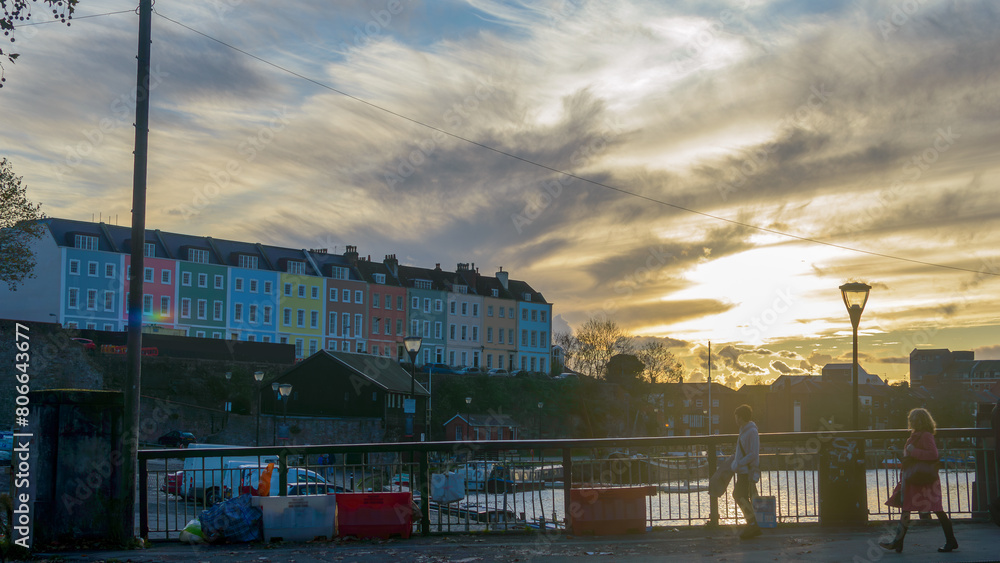 View over Bristol Redcliffe Wharf during golden hour, Pedestrians walking on Redcliffe Bascule Bridge and watching colourful houses