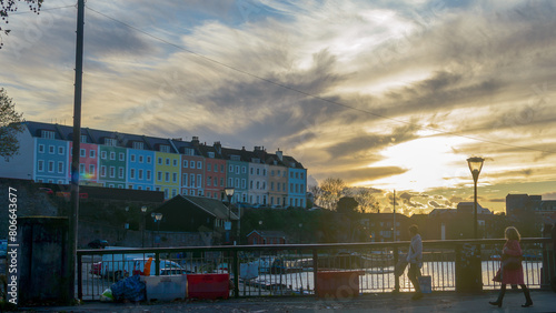 View over Bristol Redcliffe Wharf during golden hour, Pedestrians walking on Redcliffe Bascule Bridge and watching colourful houses photo