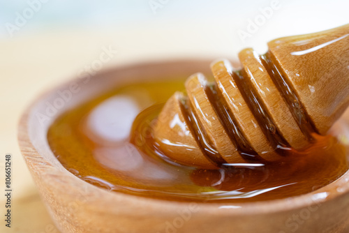 Extreme Close up of Honey Dipper Placing in Small Bowl of Honey