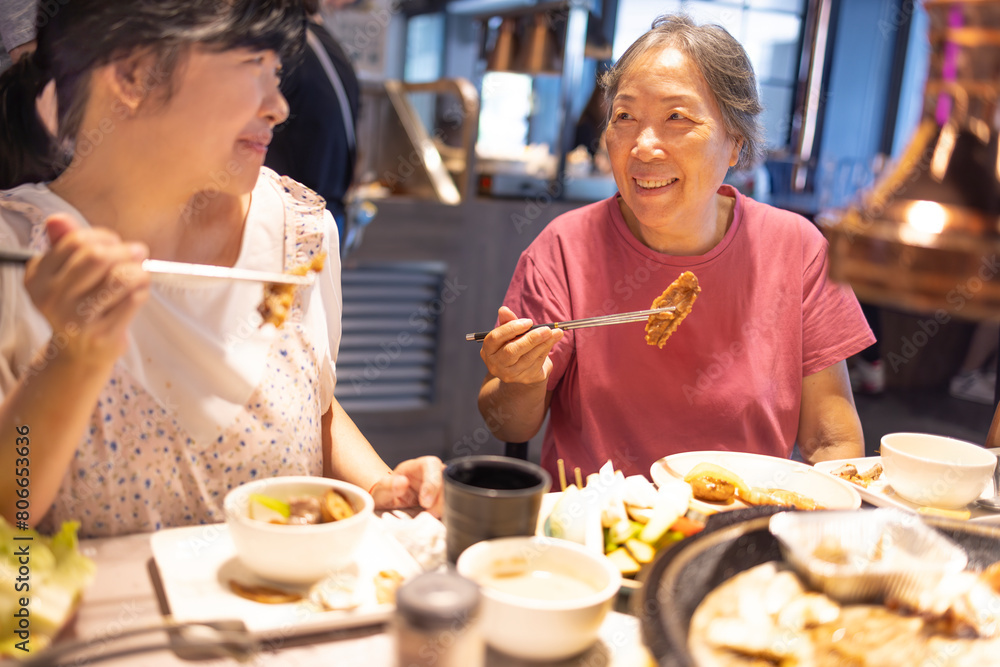 Happy mother and daughter celebrating mothers day at restaurant