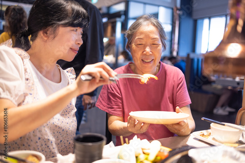 Happy mother and daughter celebrating mothers day at restaurant