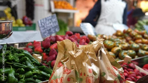 Authentic farmer's market with fresh fruits and vegetables. People buy food at the farmer's market and pay for it.