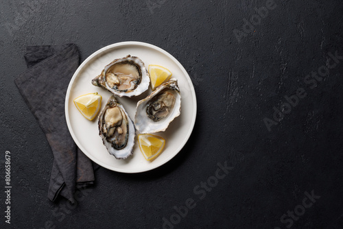 Fresh oysters with lemon on plate photo