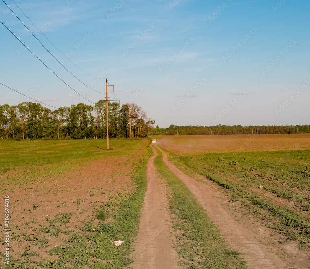 the car drove along a dirt road in the distance the car drove along a dirt road in the distance