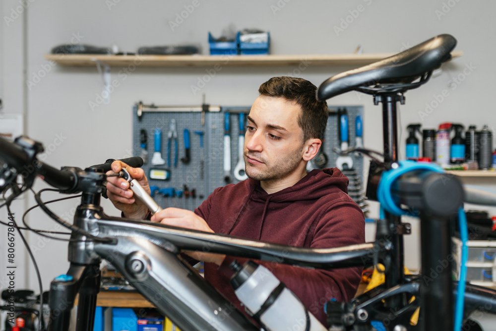 The mechanic uses an Allen ratchet wrench on the handlebar of an electric mountain bike. The mechanic uses an Allen ratchet wrench on the handlebar of an electric mountain bike.