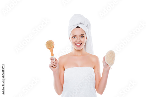 Portrait of positive cheerful woman wrapped in towel with turban on head holding bast and fetlock in hands isolated on white background photo