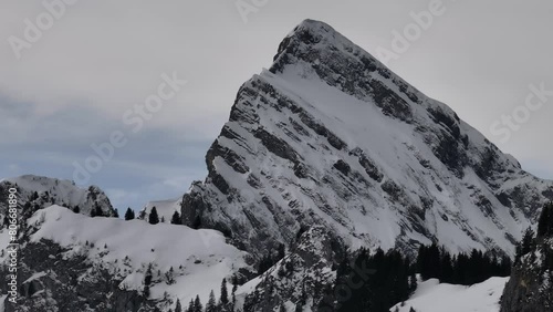 Circling Drone Shot of Large Mountain Peak Covered in Thin Blanket of Snow, Wintertime photo