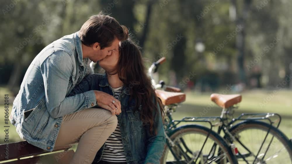 Romantic couple with bicycles kissing at the park