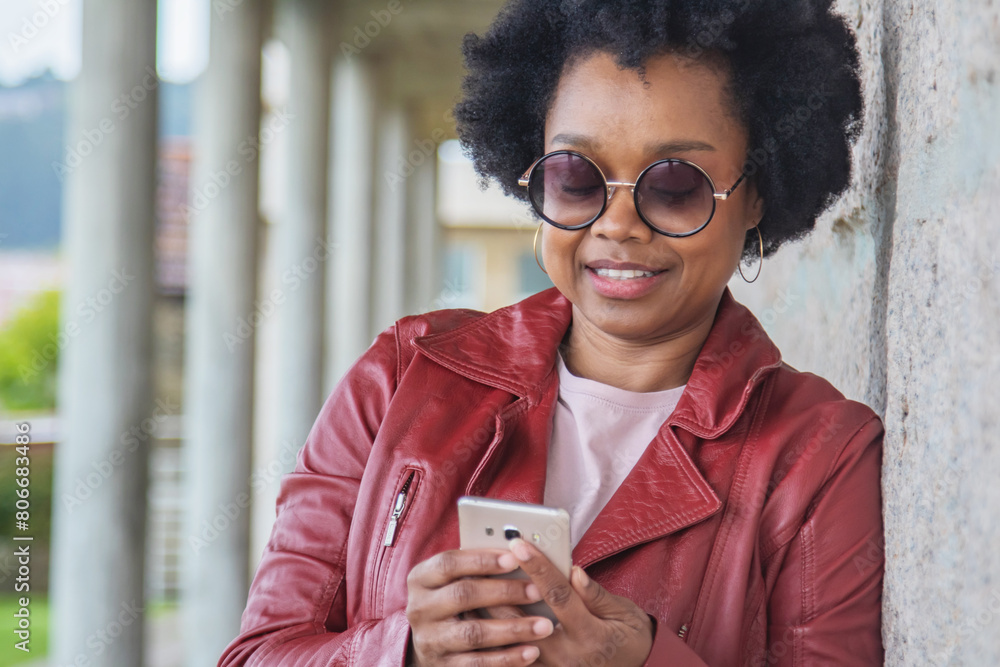Fototapeta premium retro afro young woman using phone on the street