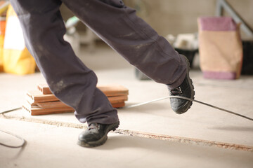 Construction worker stumbling with a cord