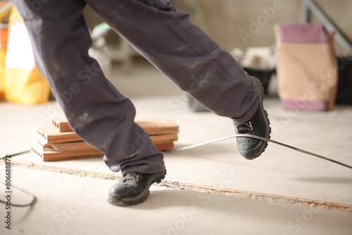 Construction worker stumbling with a cord