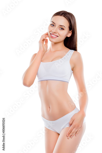 Portrait of slender thin woman with perfect body in white underwear isolated over white background holding hand on cheek and hips