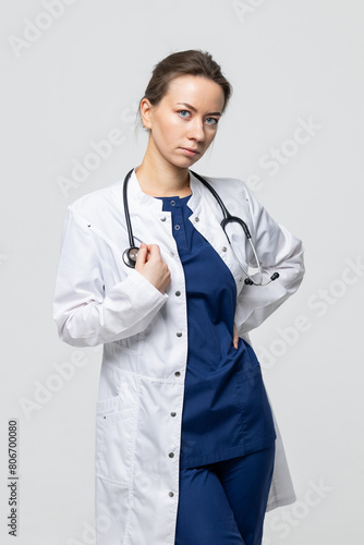 A doctor with a stethoscope around his neck and in a white coat on a white background