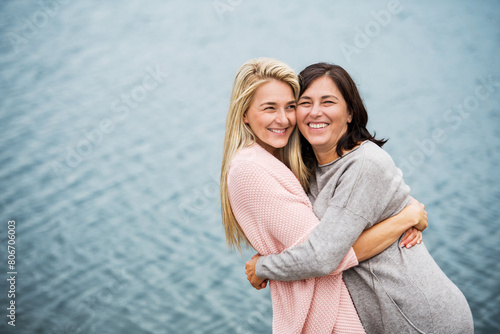 Mom and daughter on spring vacation together by lake. Mother and daugher together time in vacation resort. Unconditional, deep maternal love, Mother's Day concept.