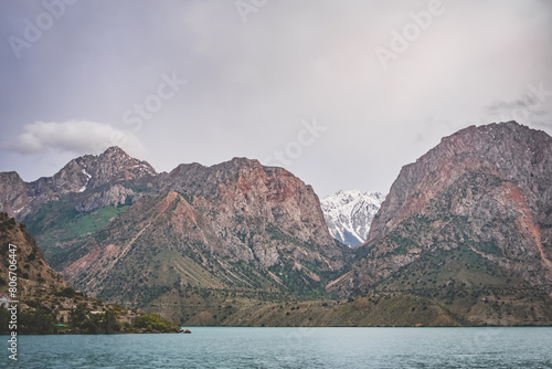 Panoramic view of blue Iskanderkul lake and rocky mountains in Tajikistan on a cloudy cloudy day photo