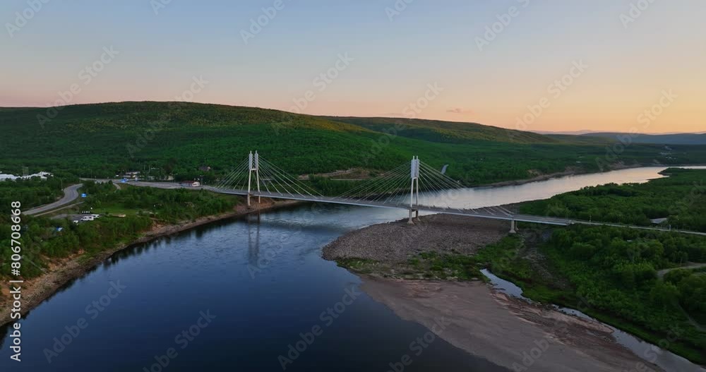 Aerial view orbiting the Sami Bridge and river, sunset in Utsjoki, Finland Aerial view orbiting the Sami Bridge and river, sunset in Utsjoki, Finland