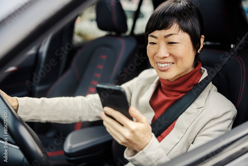 A japanese woman driving her car and looking at the cellphone. © dusanpetkovic1