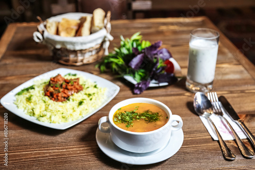 Wooden Table With Bowl of Soup and Plate of Food