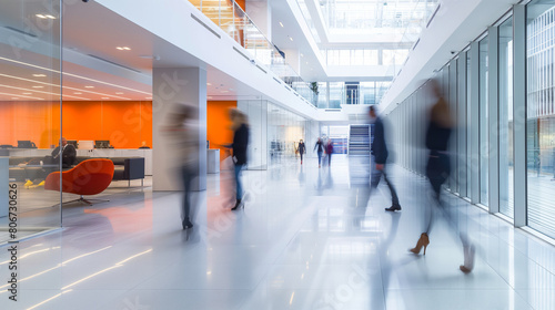 Figures glide across the bright business workplace in blurred motion, their purposeful strides contributing to the lively atmosphere of the modern office space.