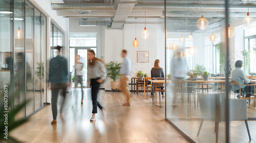 In the fast-paced environment of the modern office, people move swiftly in blurred motion, their actions contributing to the bustling energy of the bright business workplace. photo