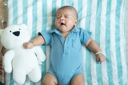 Lazy adorable asian baby boy yawning and relax on bed,Newborn child