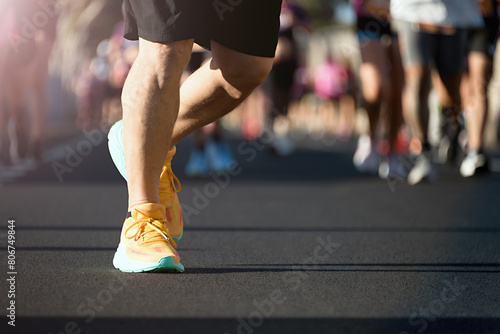 Marathon running in the light of morning. People feet on city road