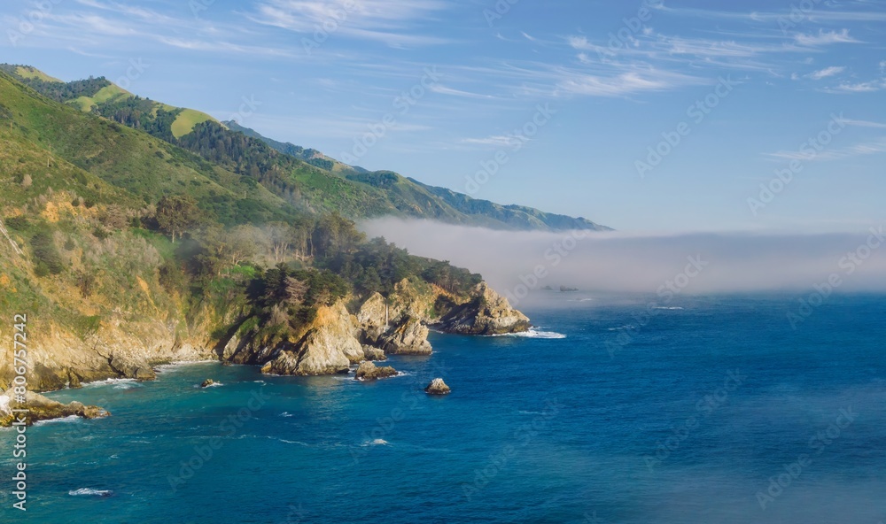 Rocks and wild foggy ocean coastline in Big Sur. San Simeon, California, United States of America. Rocks and wild foggy ocean coastline in Big Sur. San Simeon, California, United States of America.