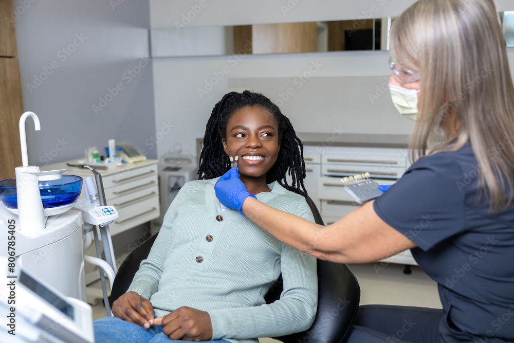 Long-haired female dentist in mask looking serious while working with patient Long-haired female dentist in mask looking serious while working with patient
