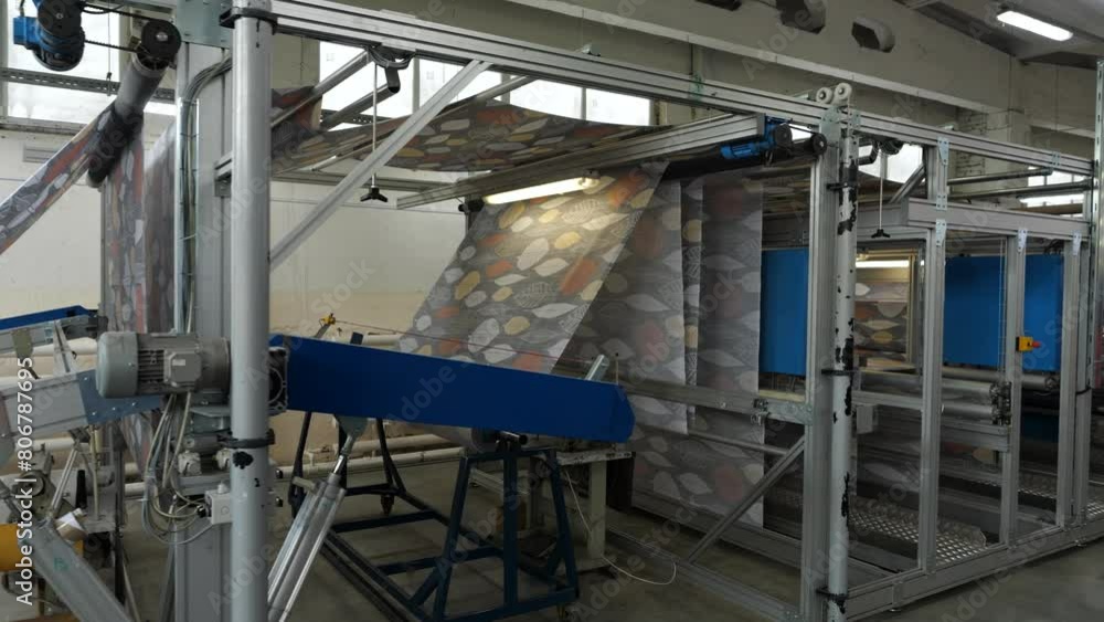 Unwinding machine for heavy rolls of fabric at textile factory. Measuring length Unwinding machine for heavy rolls of fabric at textile factory. Measuring length