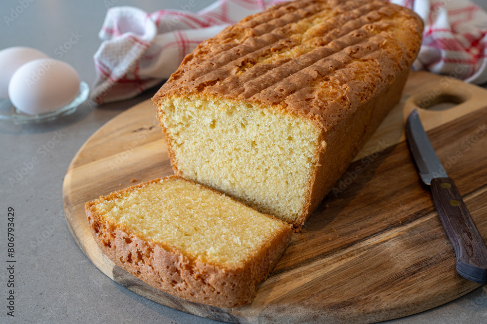 Fresh baked homemade cake on a counter ready to eat. Presented on a wooden tray with a knife to cut some pieces for the guests. Fresh baked homemade cake on a counter ready to eat. Presented on a wooden tray with a knife to cut some pieces for the guests.