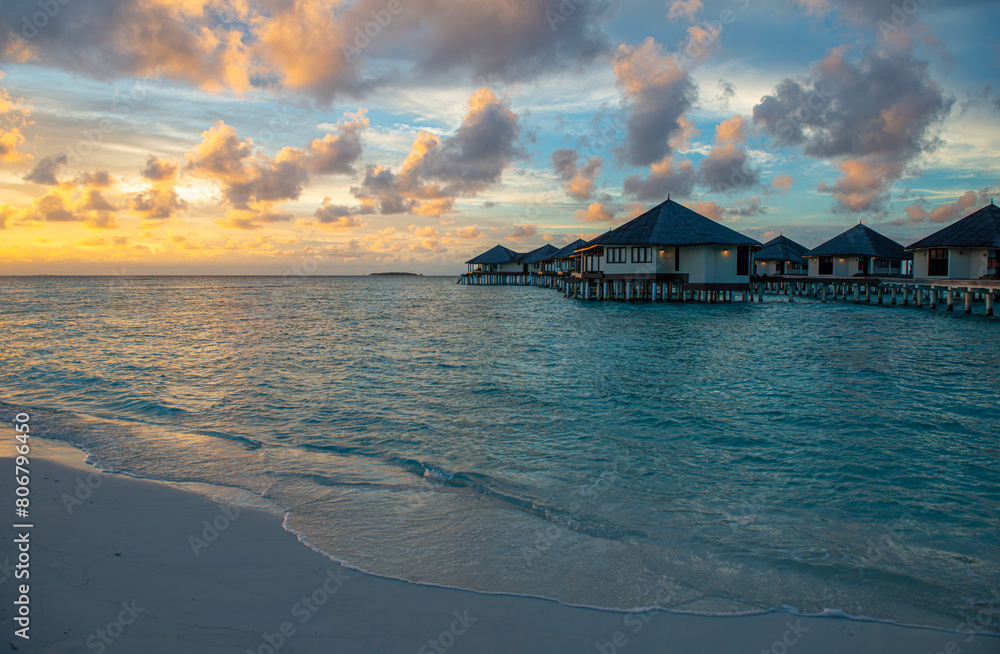 Incredible sunset in Maldives. Sea view of luxury holiday villas with soft led lights under colorful sky. beautiful twilight sky