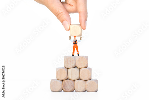 Miniature worker on stack of wooden cube isolate on white background, business goal concept