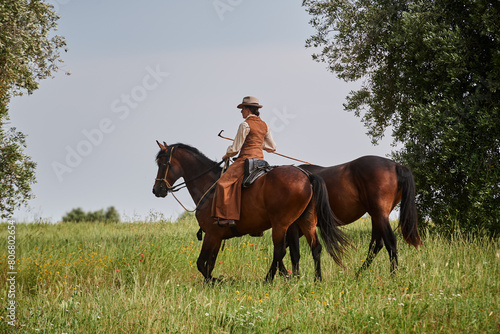 Beautiful Italian woman, riding her Maremmano horse and handling her yearling